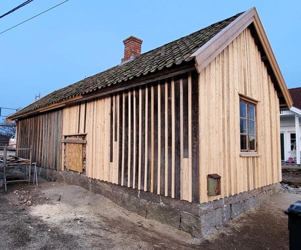 An older house in new vertical cladding, still unpainted