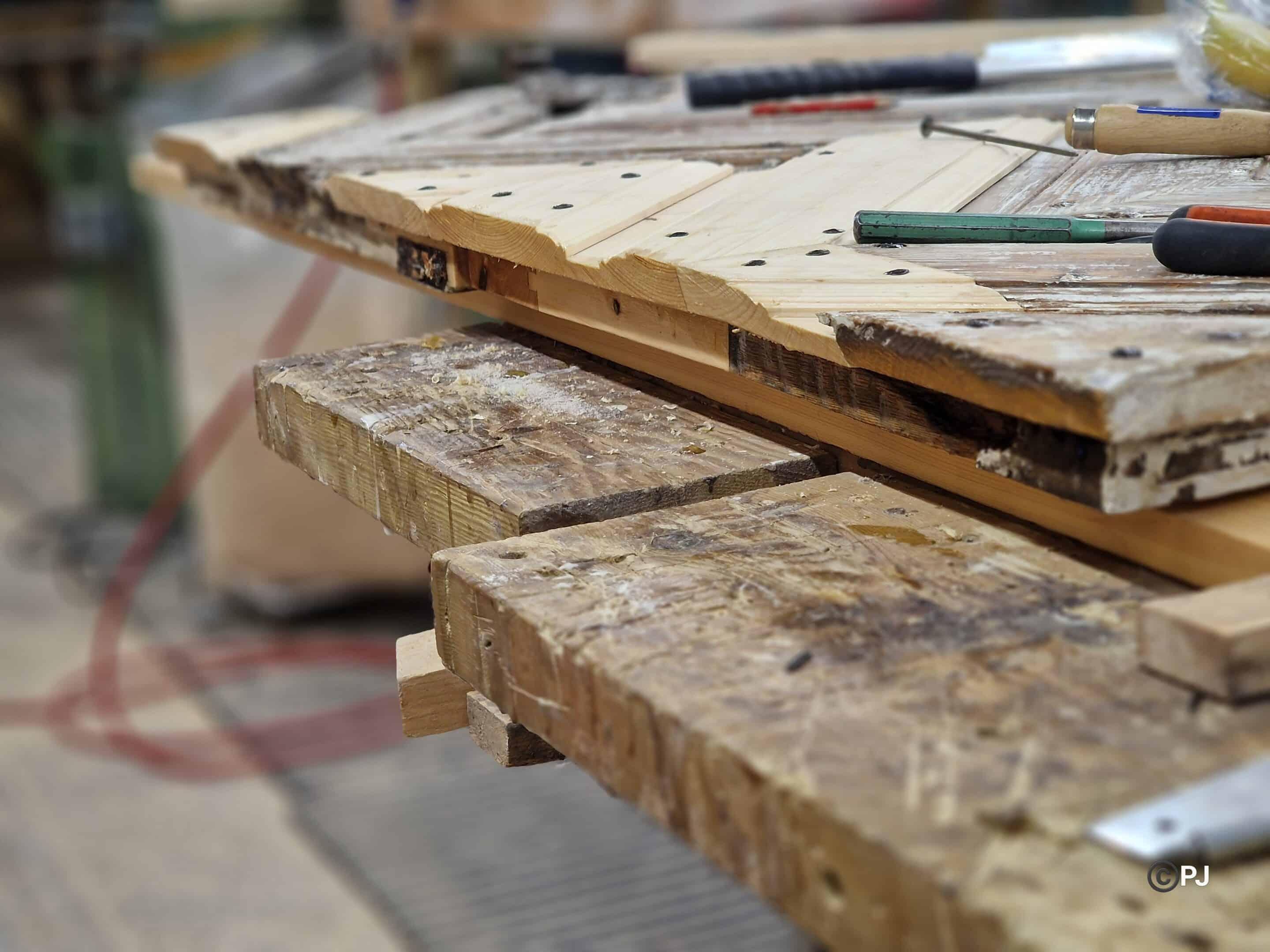 Old planed boards stacked on the workshop bench