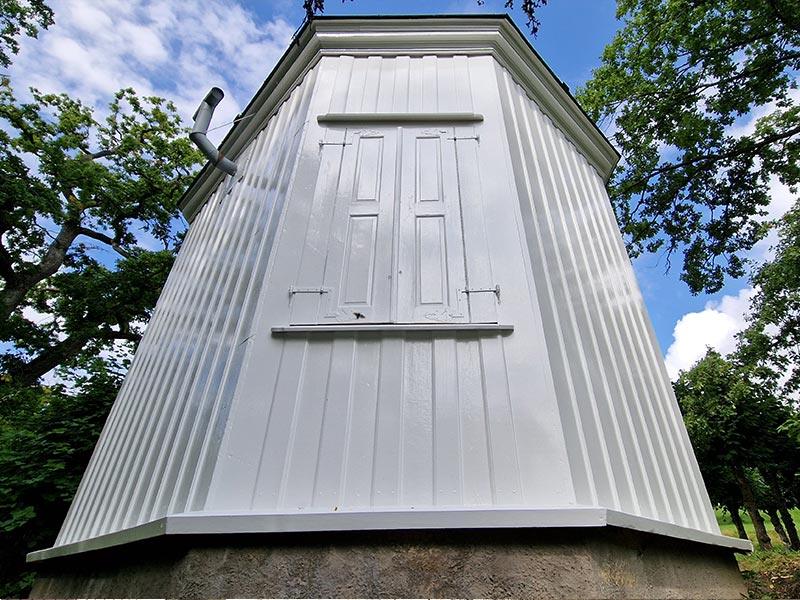 A small white-painted tower on an old building, newly restored