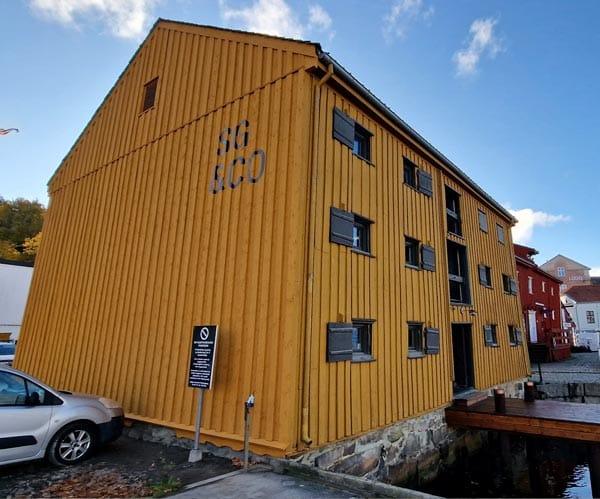 A tall ochre timber building against a blue sky